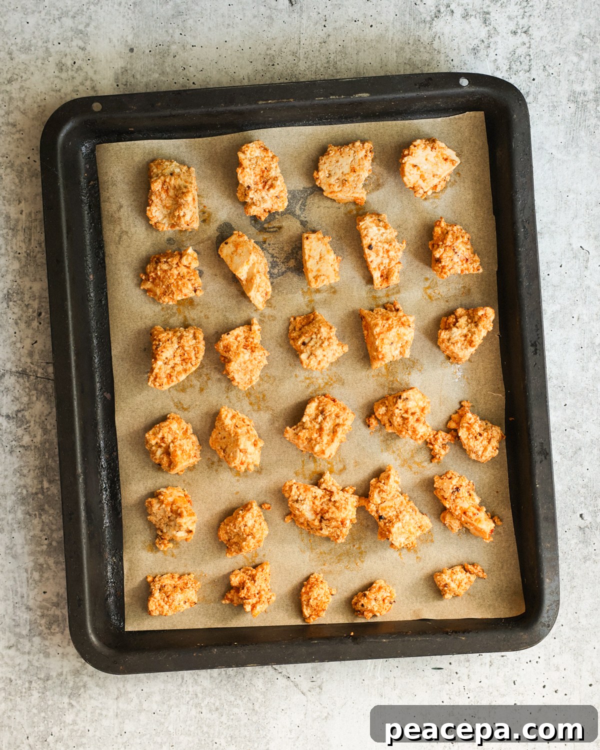 overhead of marinated tofu on baking sheet