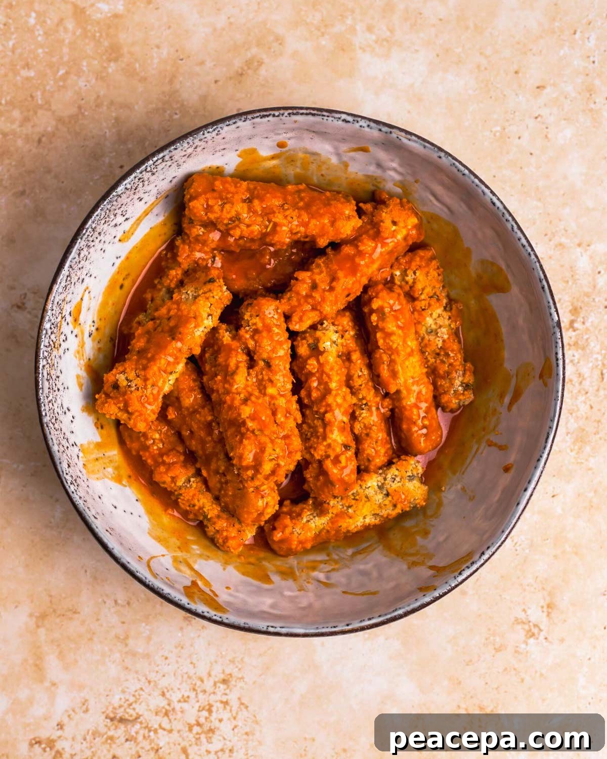 overhead of vegan wings tossed in buffalo sauce