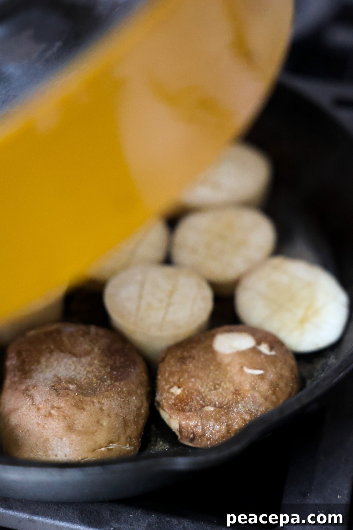 Placing a mushroom press on cooking mushrooms.