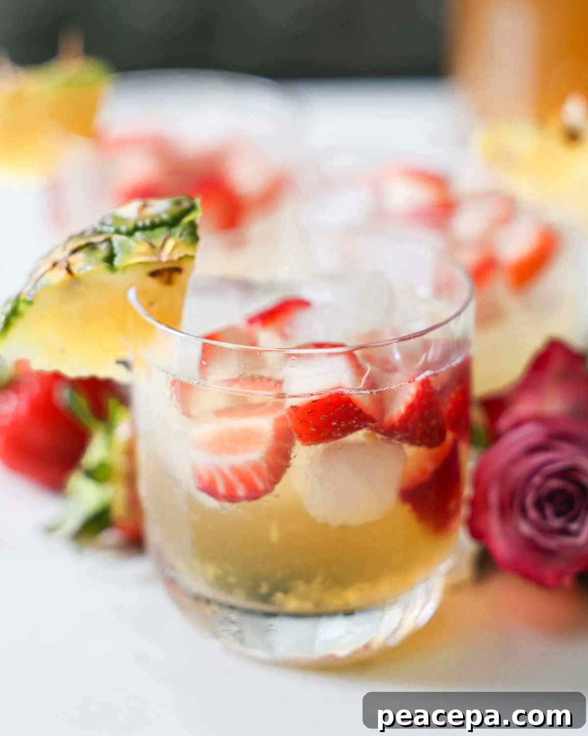 A close up shot of a small cup of pineapple summer sangria on the counter.