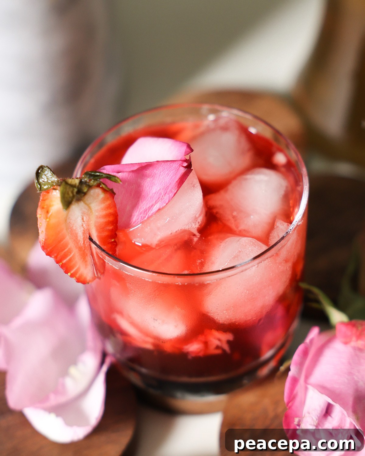 Image of a strawberry cocktail with rose simple syrup in a cocktail glass.