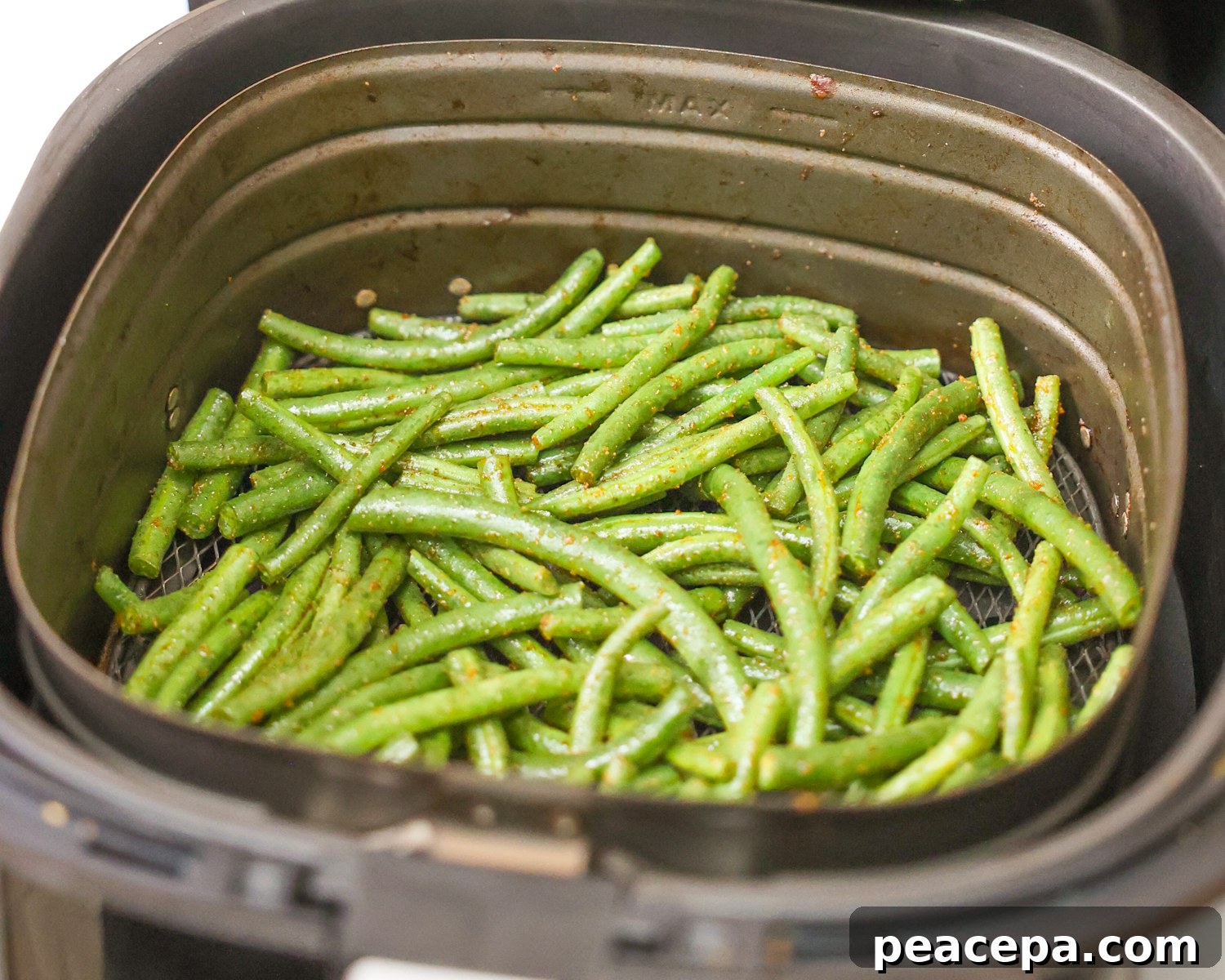 Green beans in the air fryer basket.
