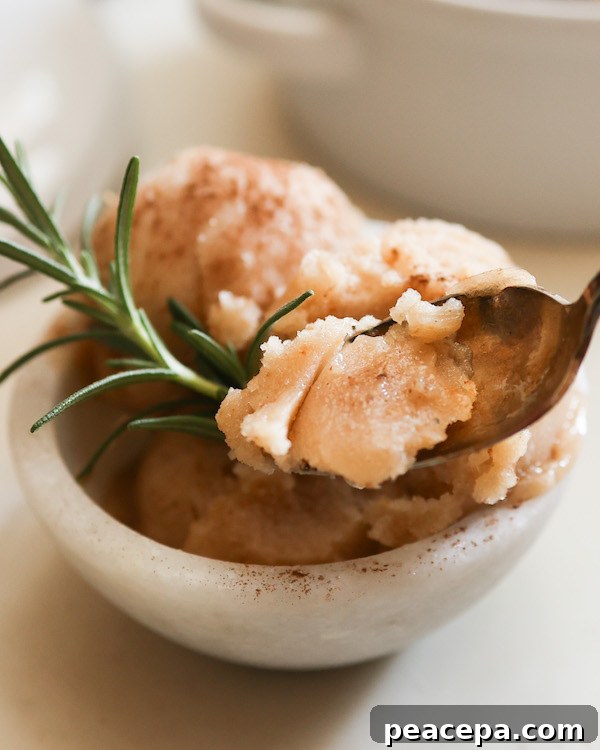 pear sorbet on spoon in front of bowl of sorbet