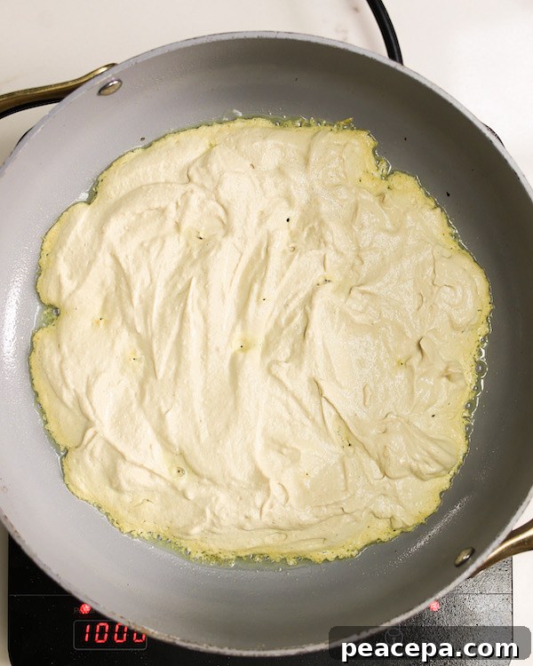 tofu omelette batter in a non-stick skillet