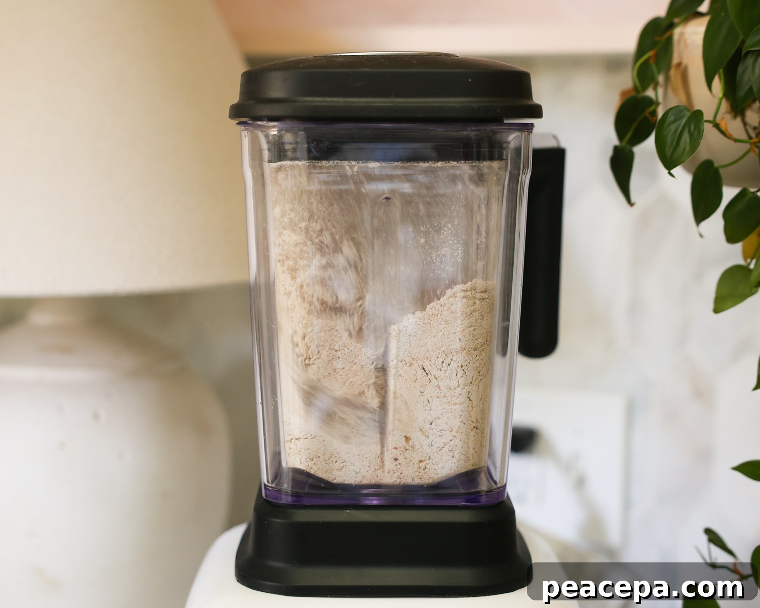Blending oats to make flour in a blender.