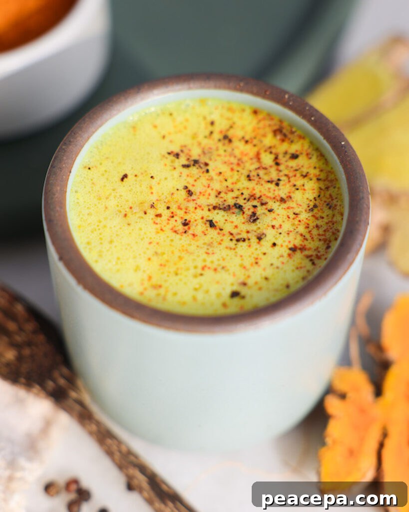 golden milk in a mug surrounded by ingredients