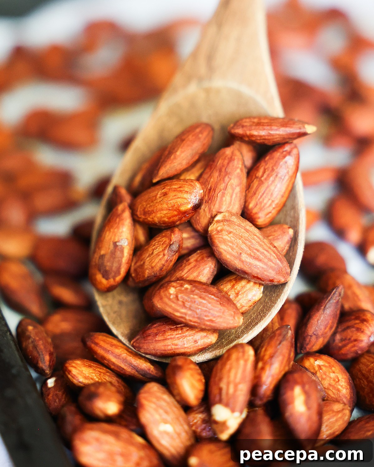 A close up of roasted tamari almonds on a baking sheet.