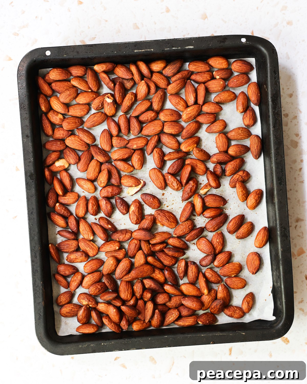An overhead shot of a pan of roasted tamari almonds.
