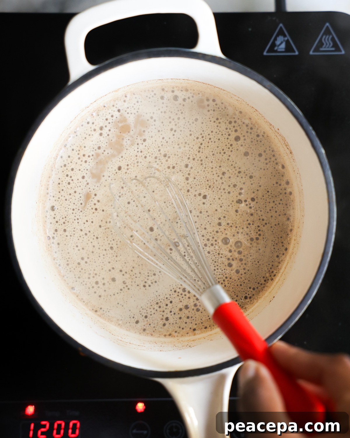 overhead of sweet potato spice latte being whisked  in saucepan