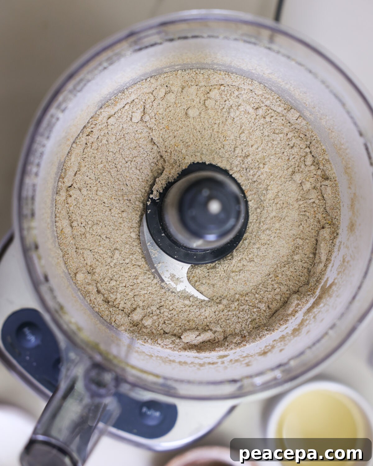 Pumpkin seed meal and spelt flour pulsed together in the bowl of a food processor.