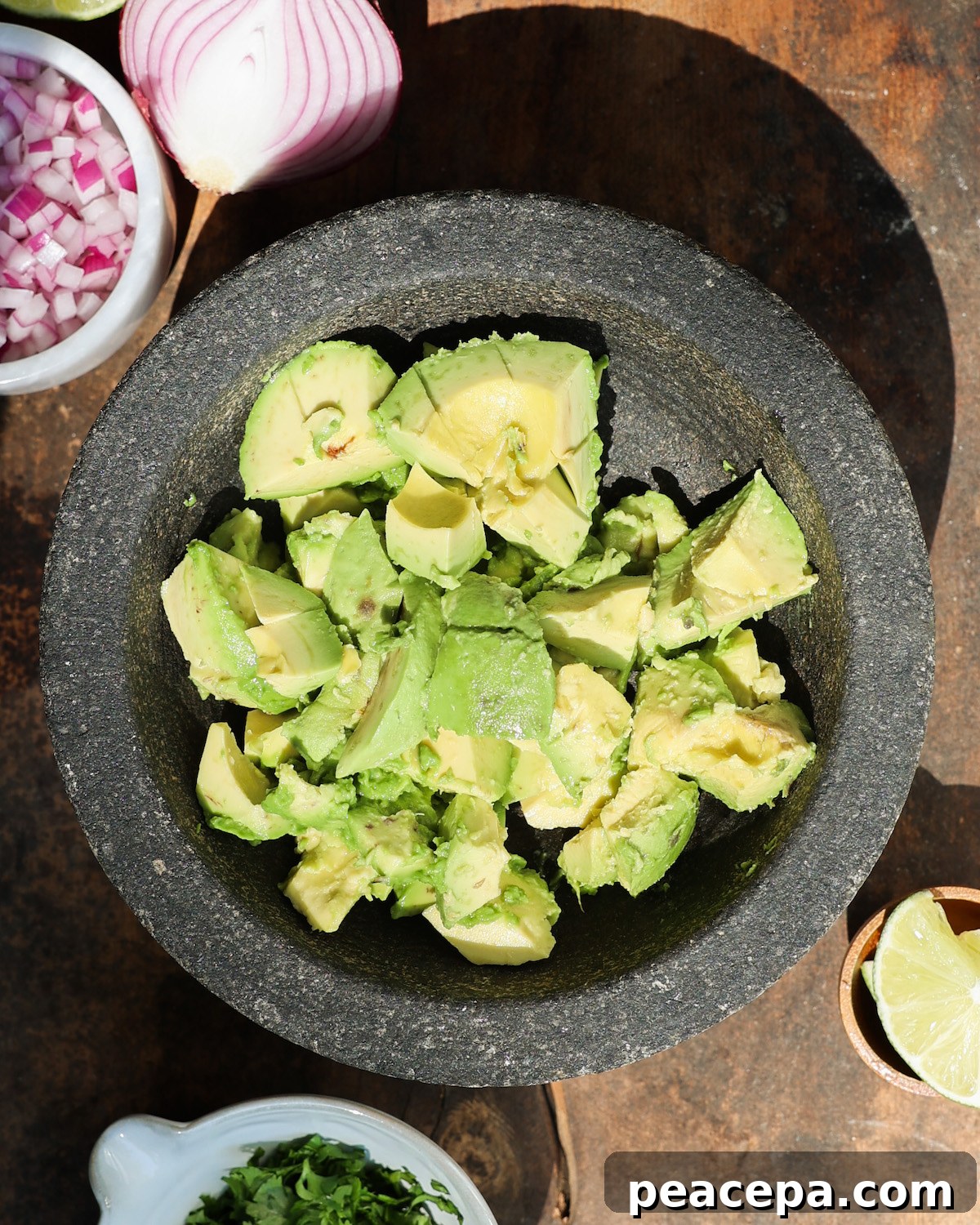 An overhead shot of cubed avocado in a mortar.