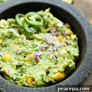 A close-up angled shot of a mortar of mango guacamole.