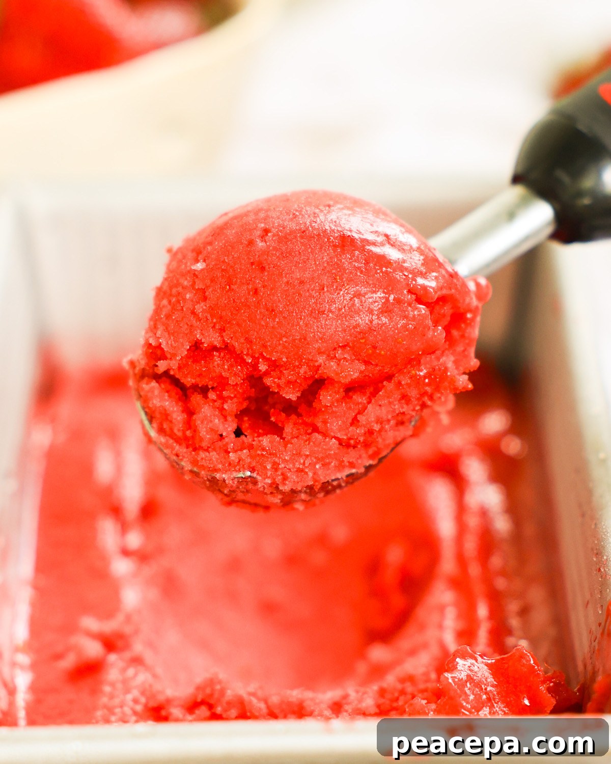 An up-close shot of a scoop of strawberry sorbet.