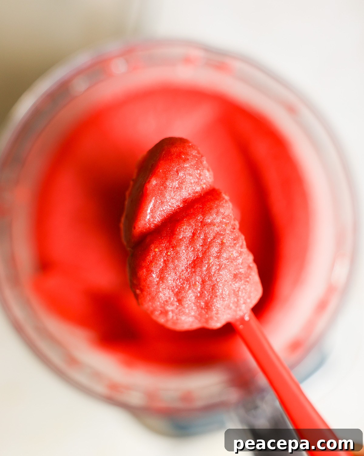 An overhead shot of a spoonful of the freshly pureed strawberry sorbet.