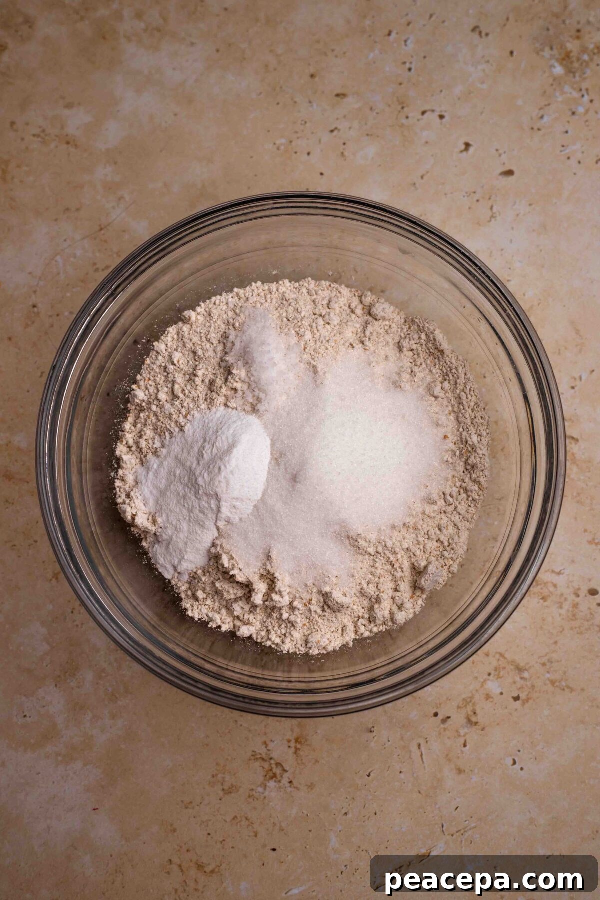 An overhead shot of the dry ingredients in a glass mixing bowl.