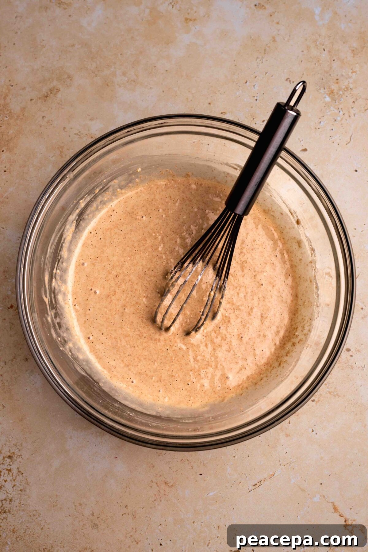 An overhead shot of a glass mixing bowl of the spelt pancake batter.