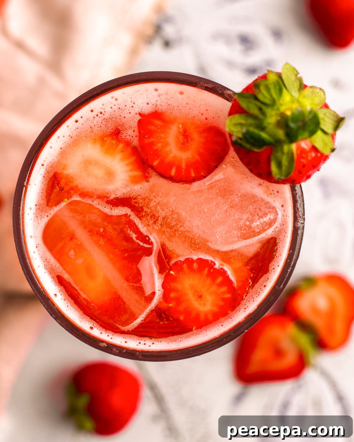 A closeup overhead shot of a glass of strawberry soda on the counter.