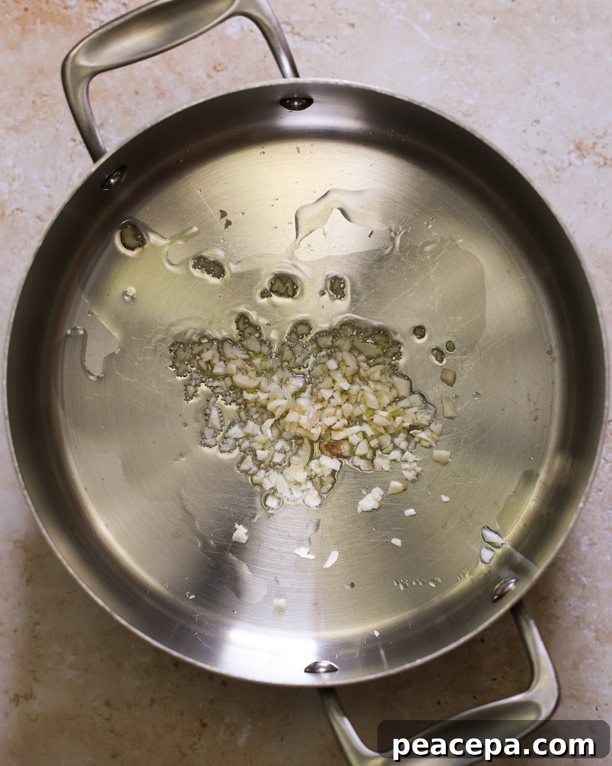 overhead of garlic sautéing in a pan