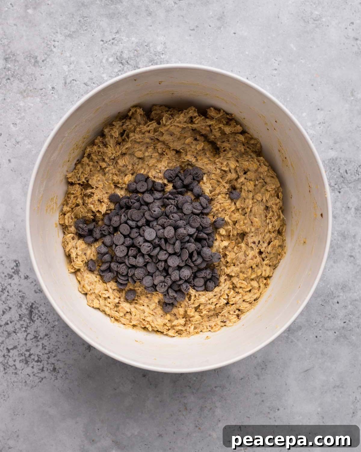 overhead of chocolate chips added to vegan cookie batter