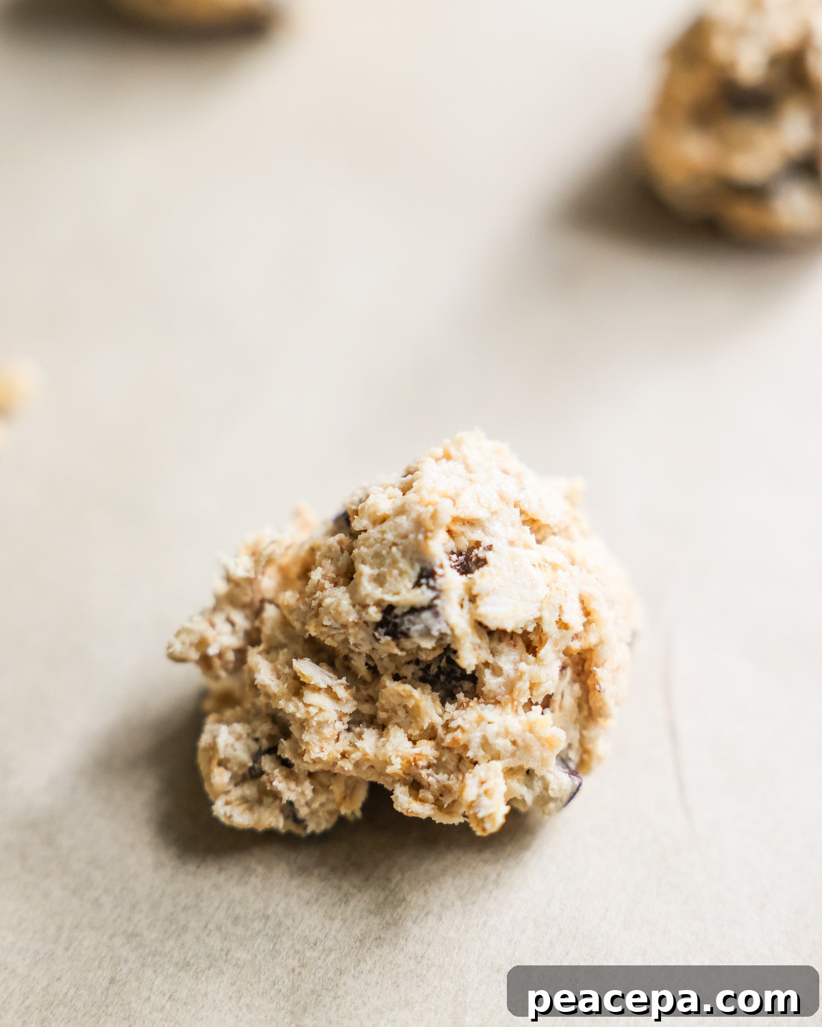 close up of vegan cookie dough ball on parchment paper