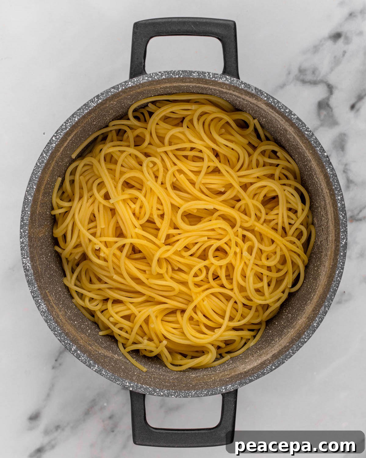 overhead of cooked and drained pasta in pot