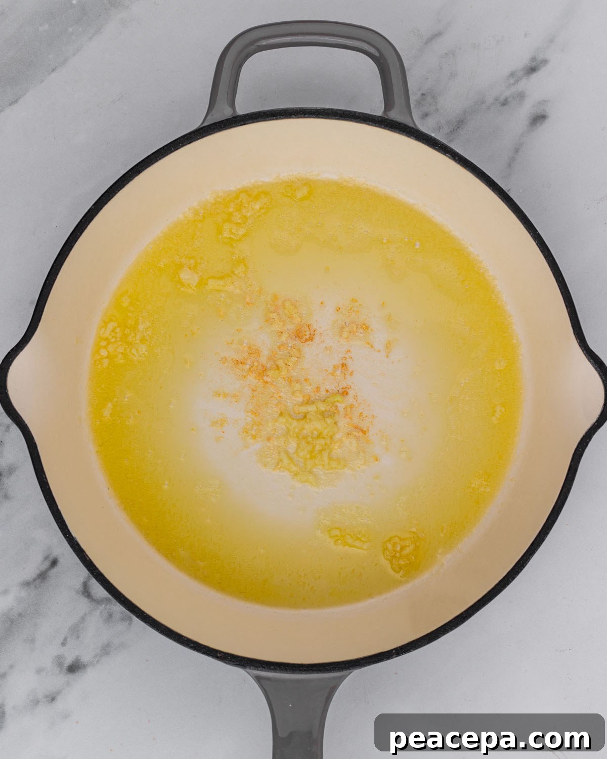 overhead of garlic sautéing in pan