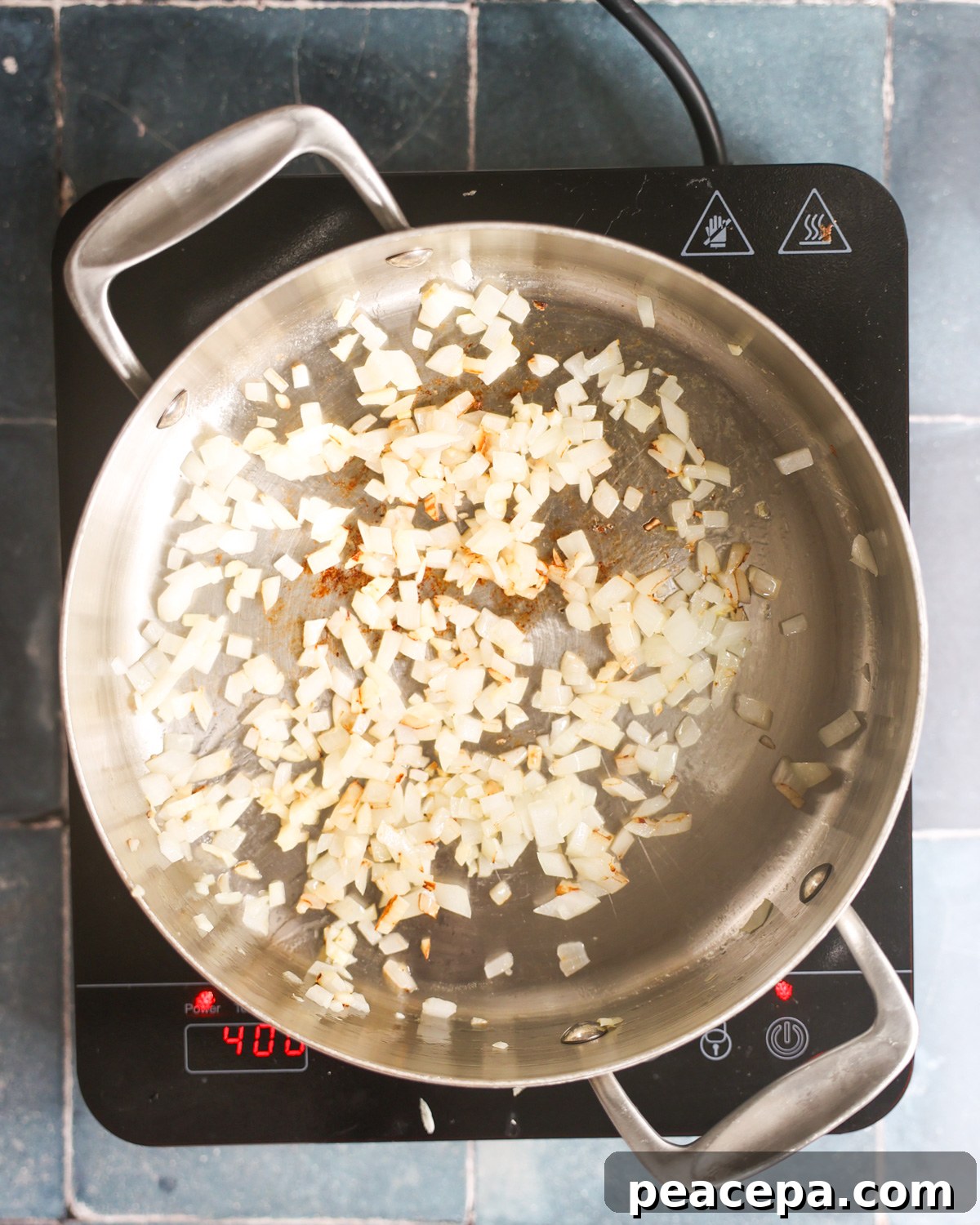 overhead of onions sautéing in pan for zucchini burgers