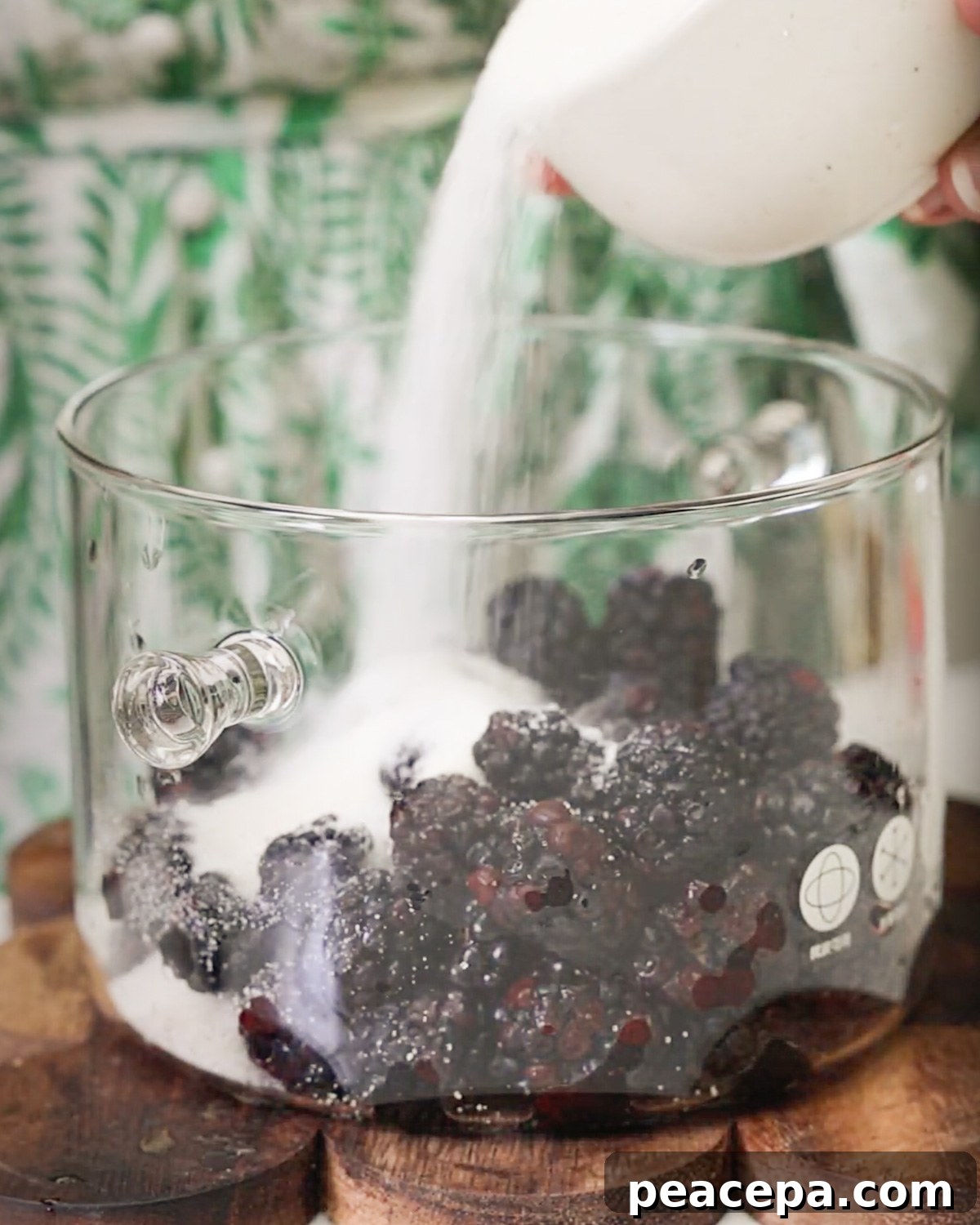 sugar being poured over blackberries