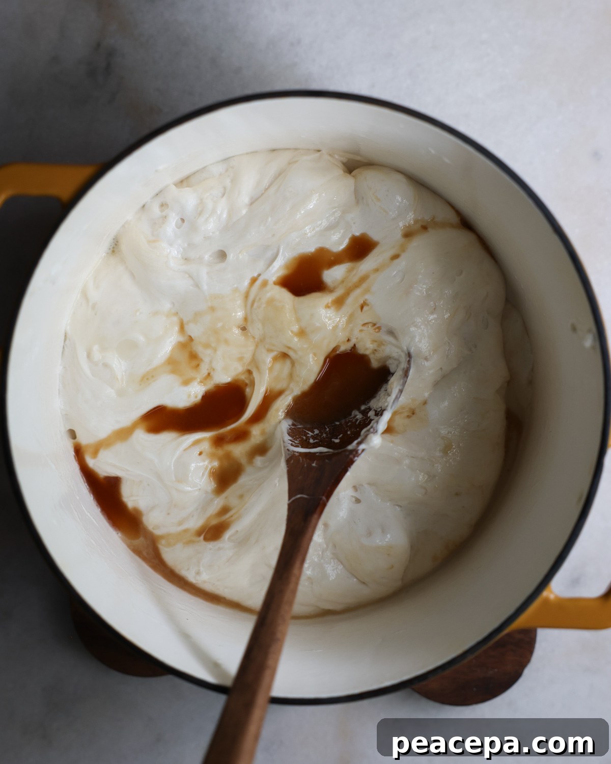 overhead of vanilla added to melted marshmallows in pot