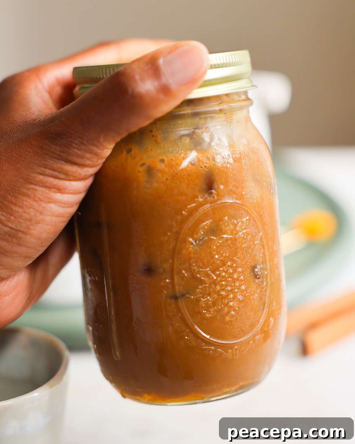 shaking a the oat milk latte in a glass jar