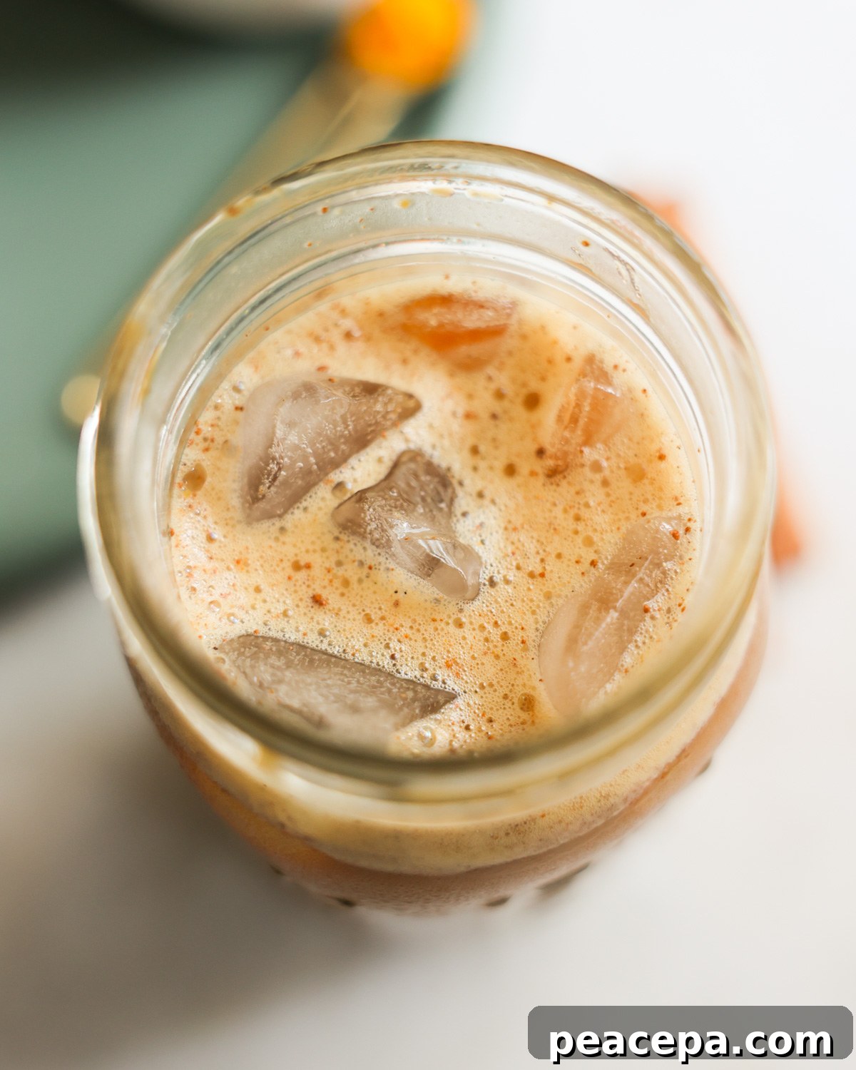 overhead of foamy oat milk iced latte in jar
