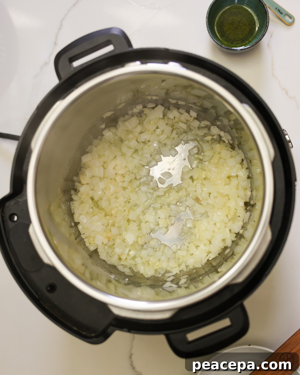 Onions sautéing in an instant pot.