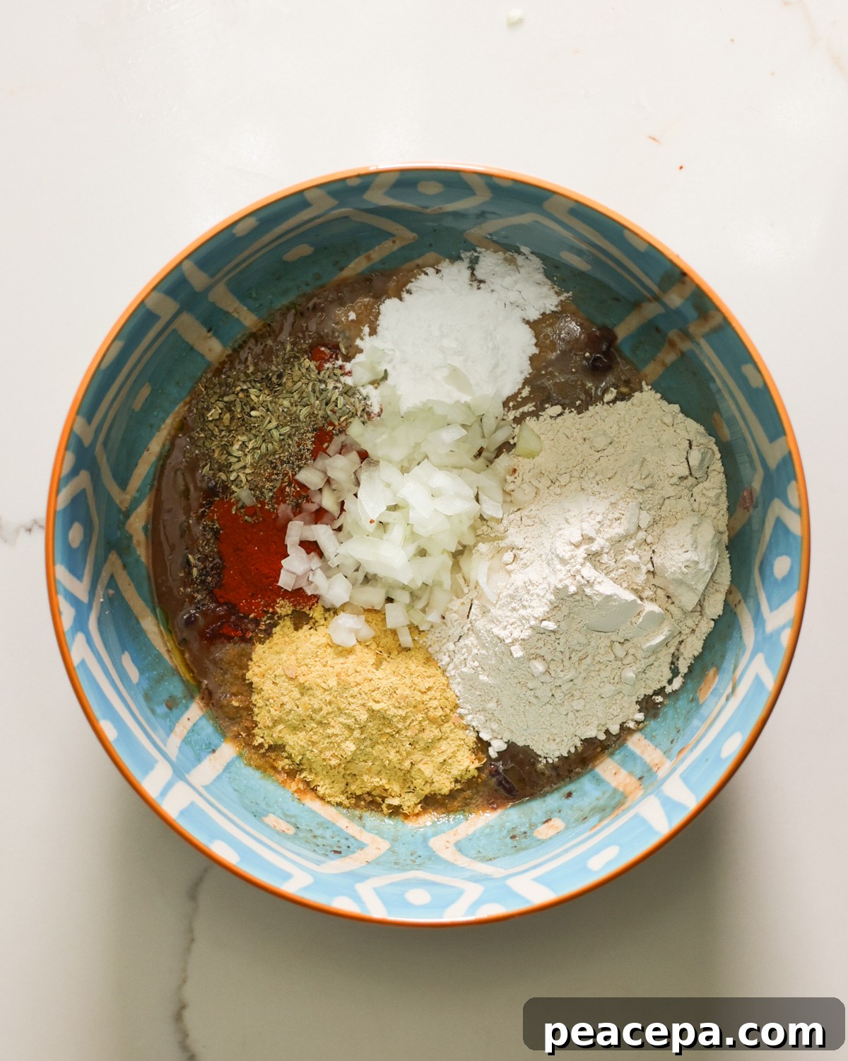 Combining the seasonings and onions in the bowl.
