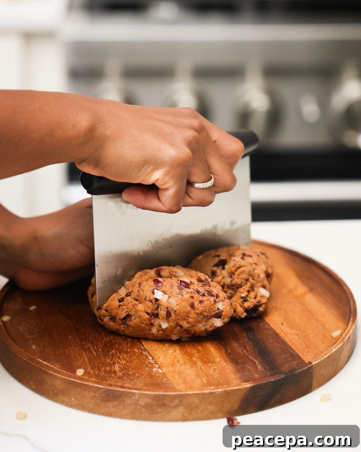 A side shot of a brown hand dividing the vegan sausage batter into 4 portions.