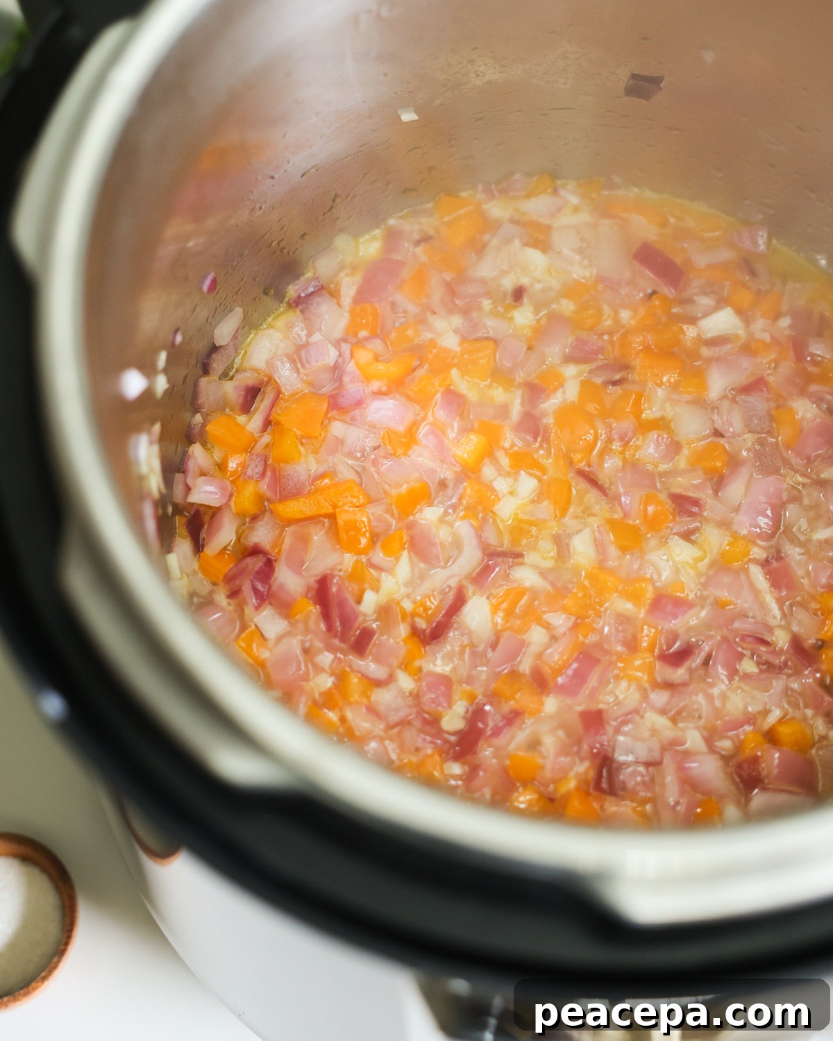 A close-up shot of veggies sauteing in an Instant Pot.