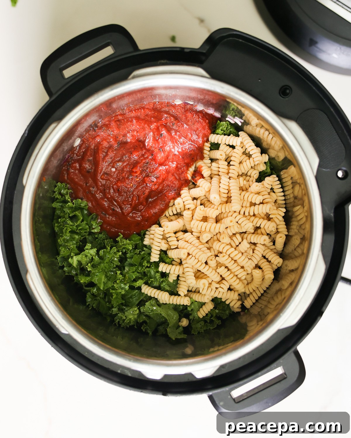 Tomato sauce, kale, and pasta in an Instant Pot.