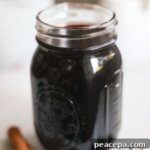 An up-close shot of a small jar of elderberry syrup.