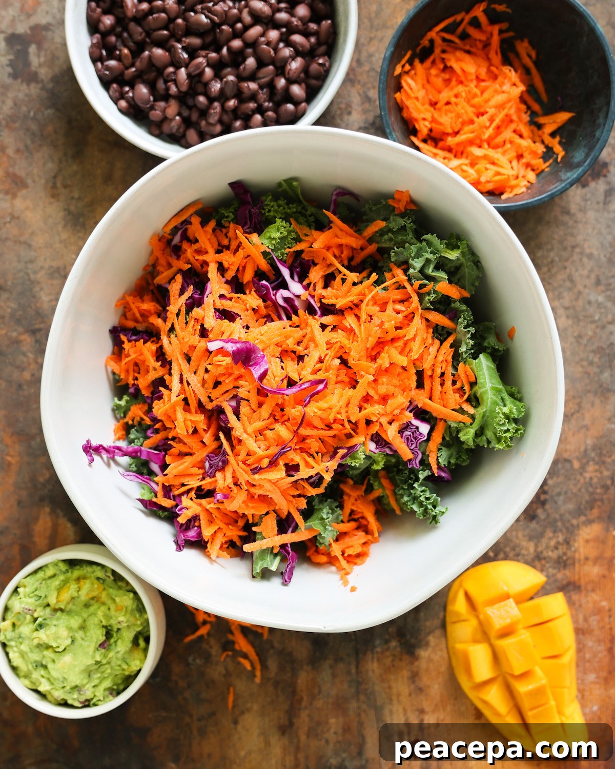 raw veggies for mango avocado salad in a large white mixing bowl