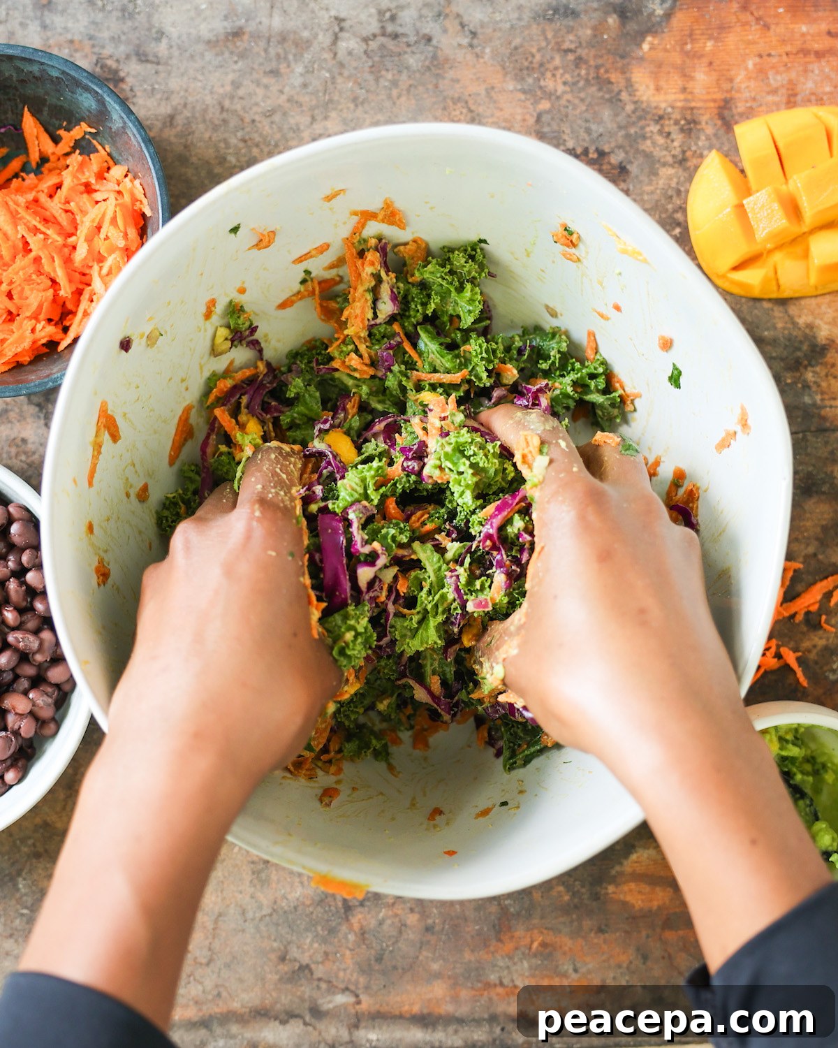 brown hands massaging salad
