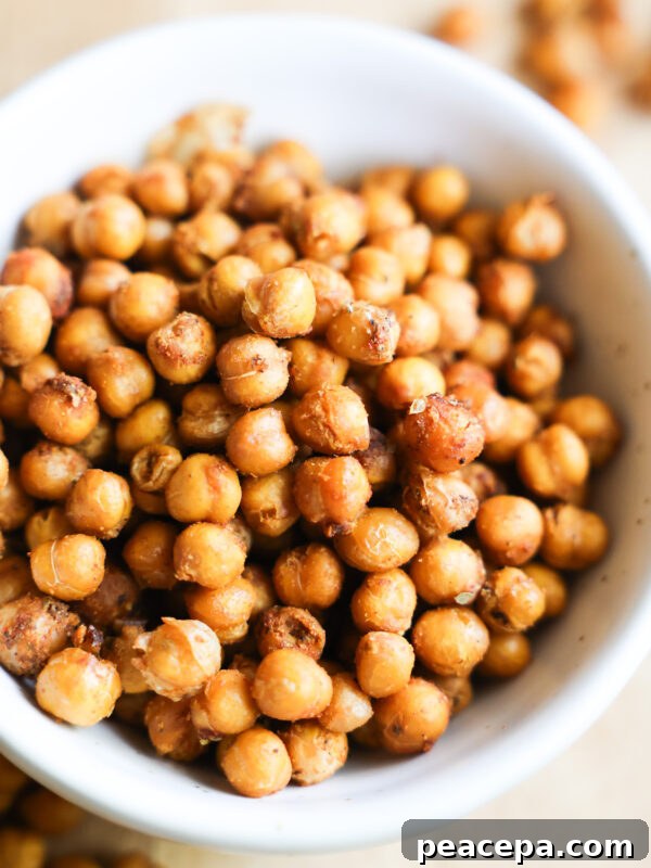 A close up shot of a white bowl of roasted chickpeas.