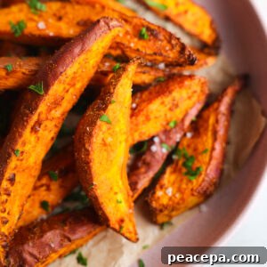 close up of sweet potato wedges on a pink plate