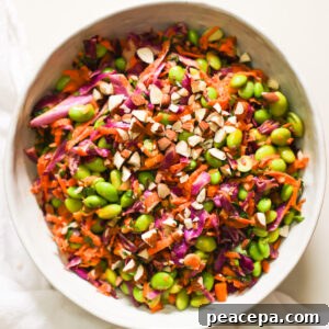 An overhead shot of a bowl of edamame salad garnished with chopped almonds.