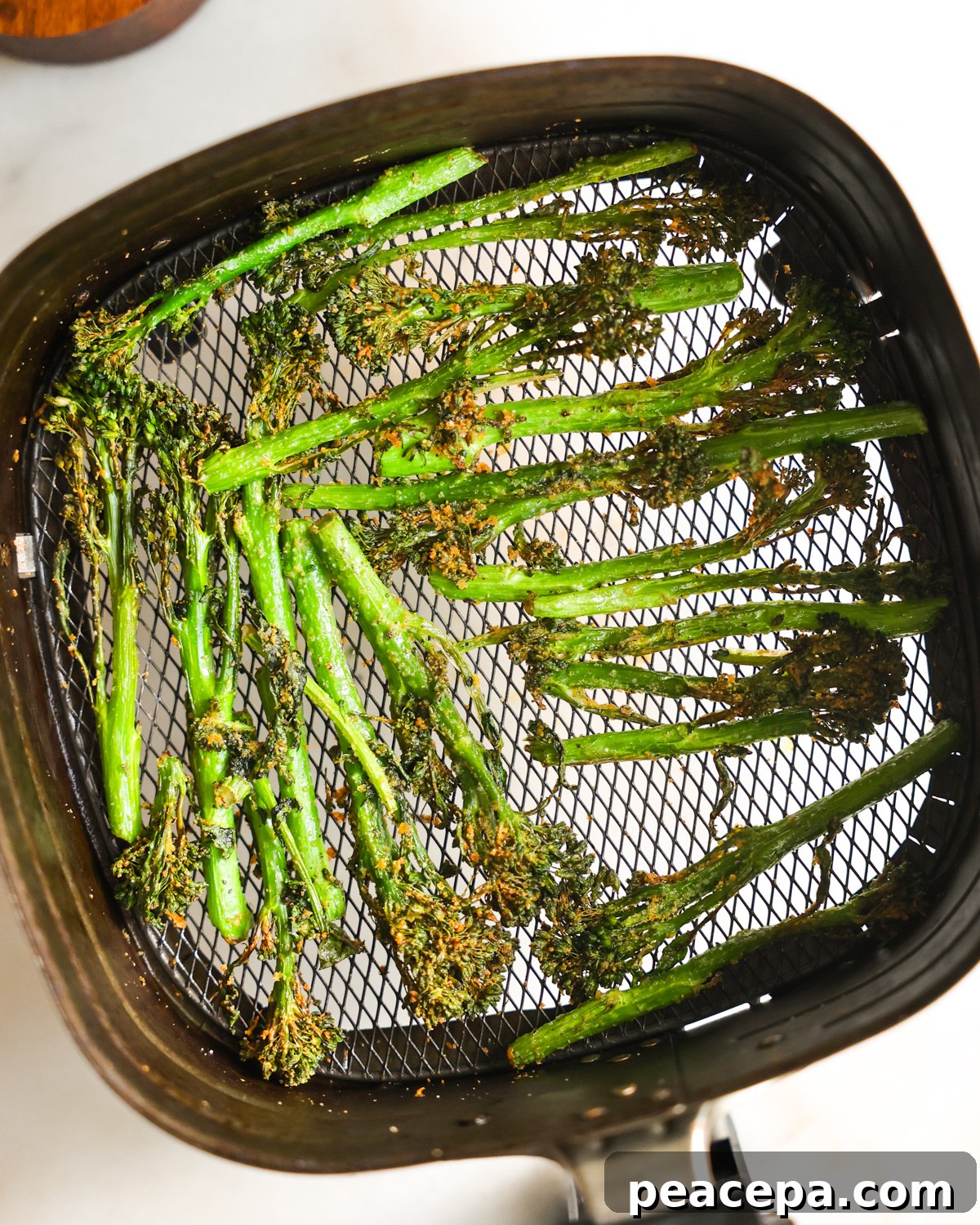 Air fry broccolini in a air fryer basket.