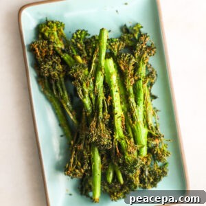 Air fryer broccolini on a small serving plate.