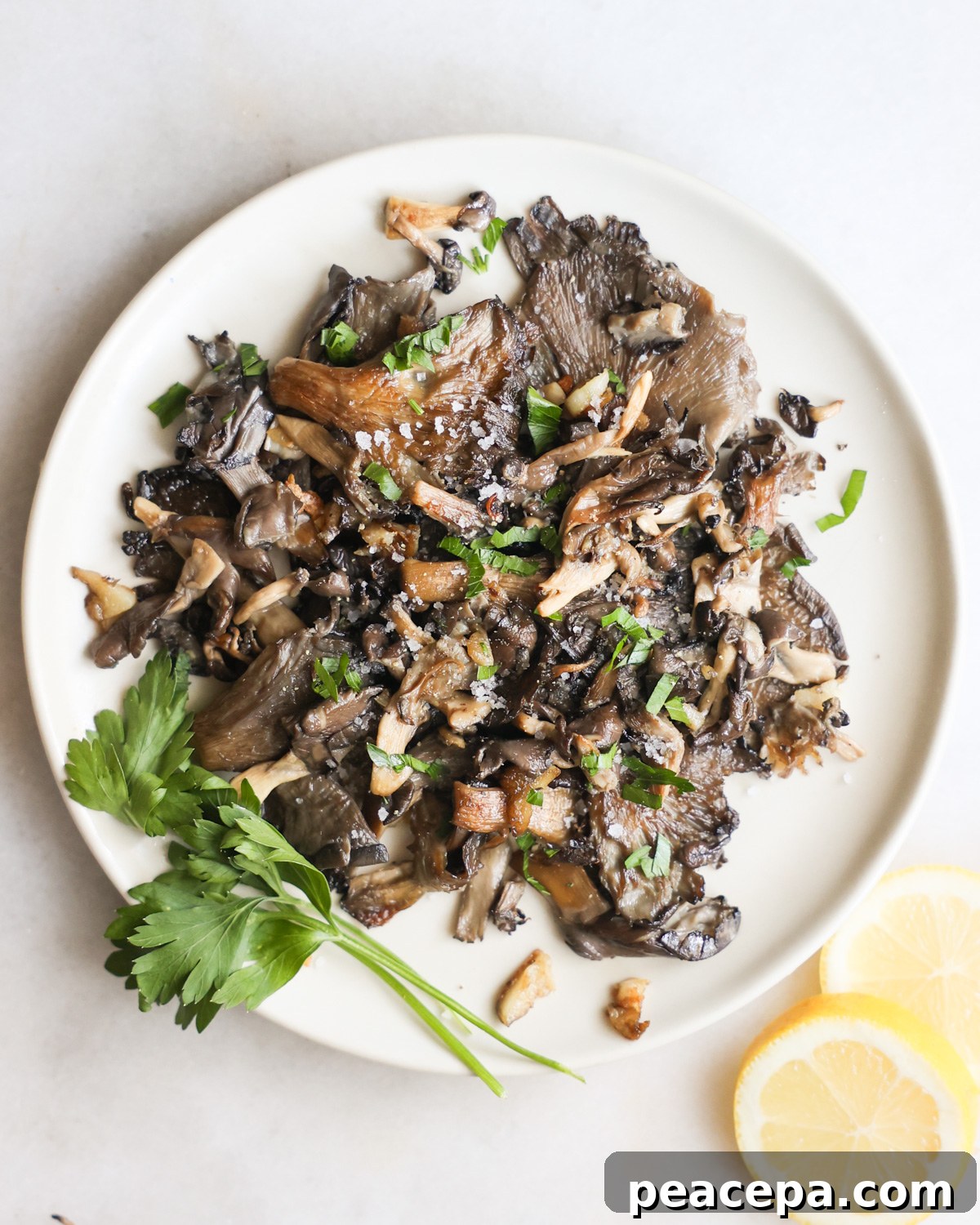overhead of pan-fried oyster mushrooms on a plate with parsley garnish
