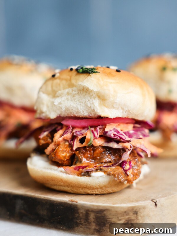 A side shot of mushroom veggie sliders on a wooden cutting board.