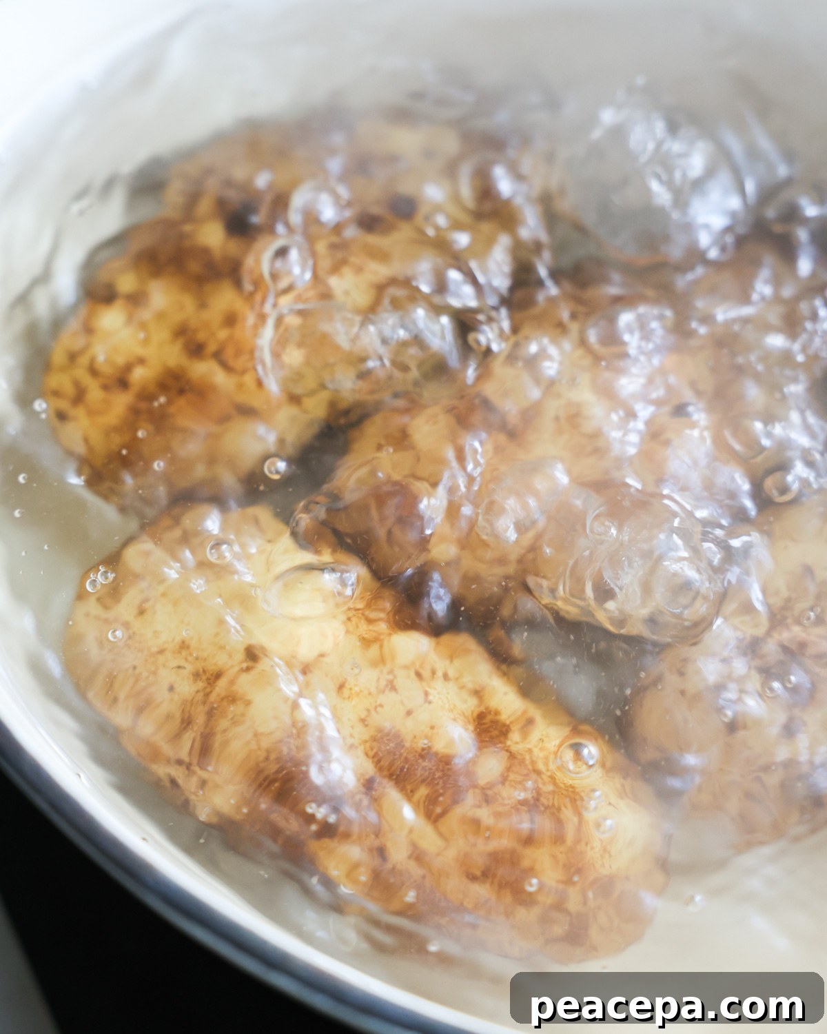 close up of potatoes boiling in a pot