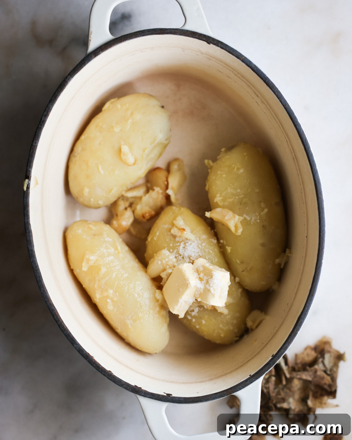overhead of russet potatoes and other ingredients in a pot 