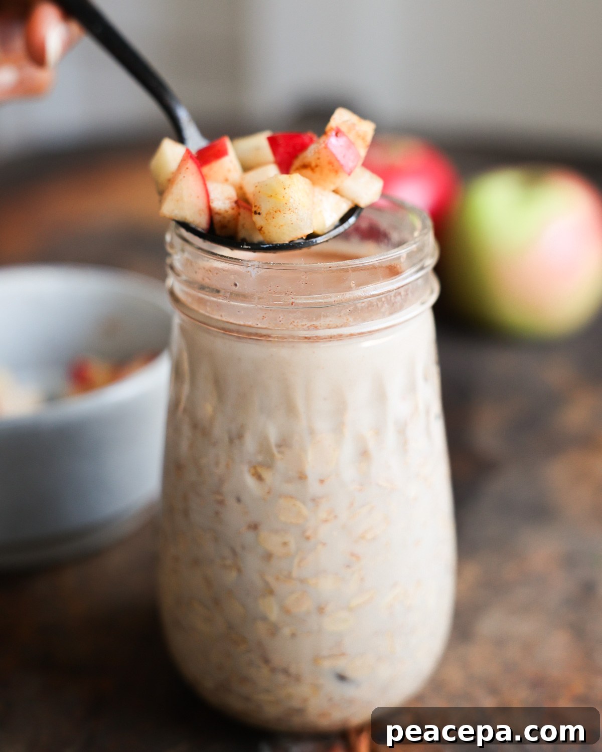 adding apple topping to oats in jar
