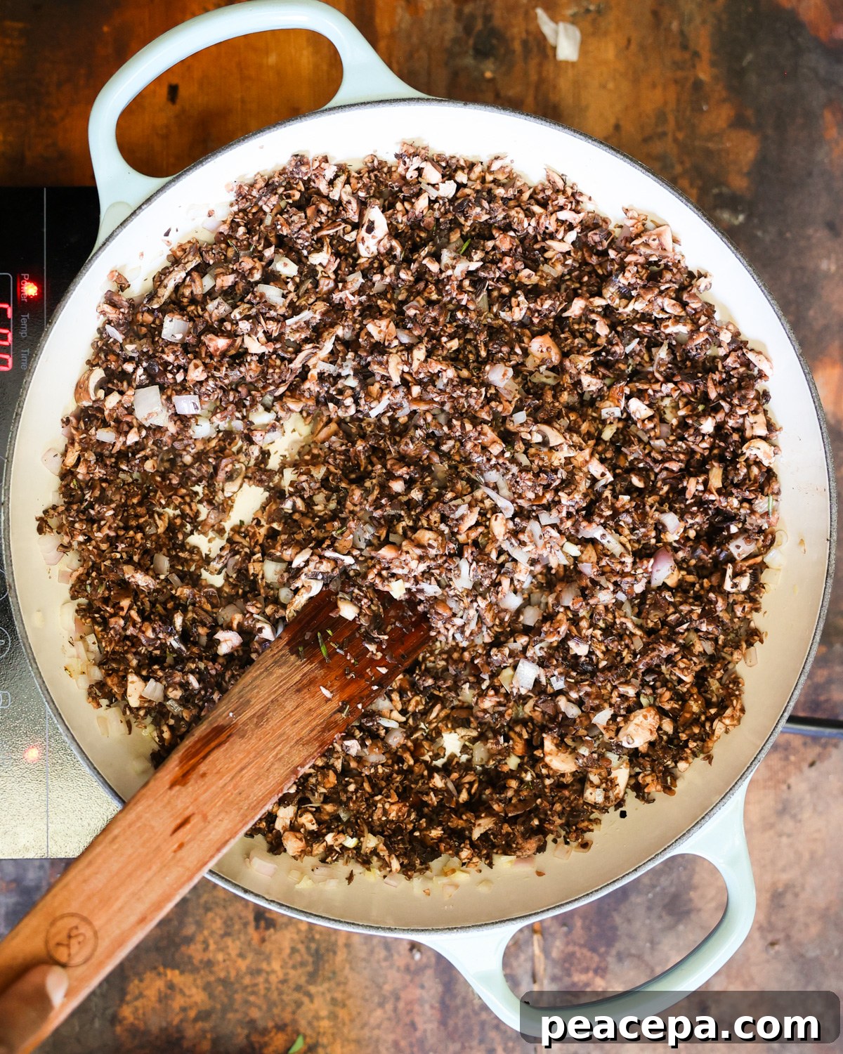 An overhead shot of the chopped mushrooms cooking in a pan.